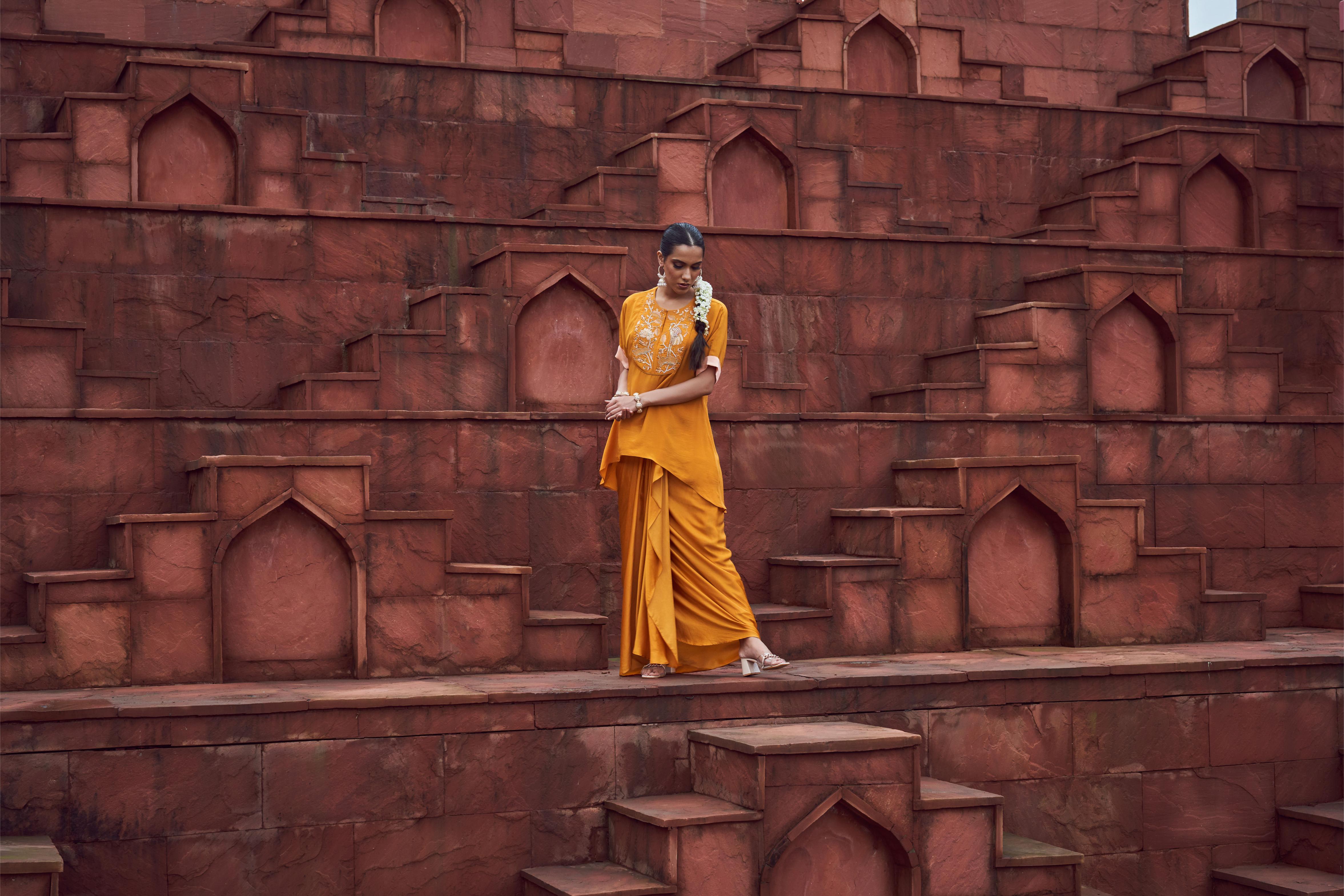 Featuring mustard yellow embroidered crepe top paired with sating dhoti skirt