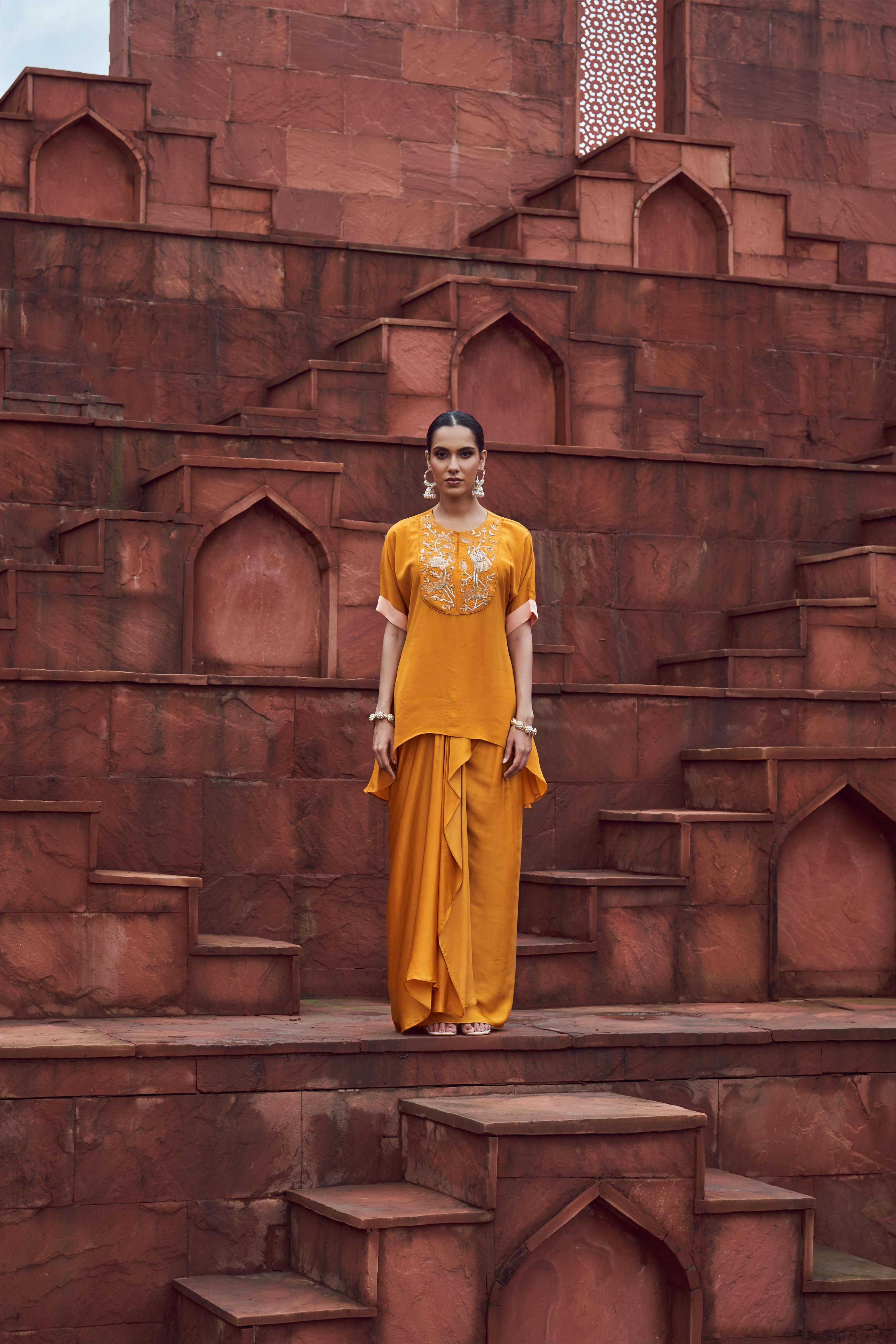 Featuring mustard yellow embroidered crepe top paired with sating dhoti skirt