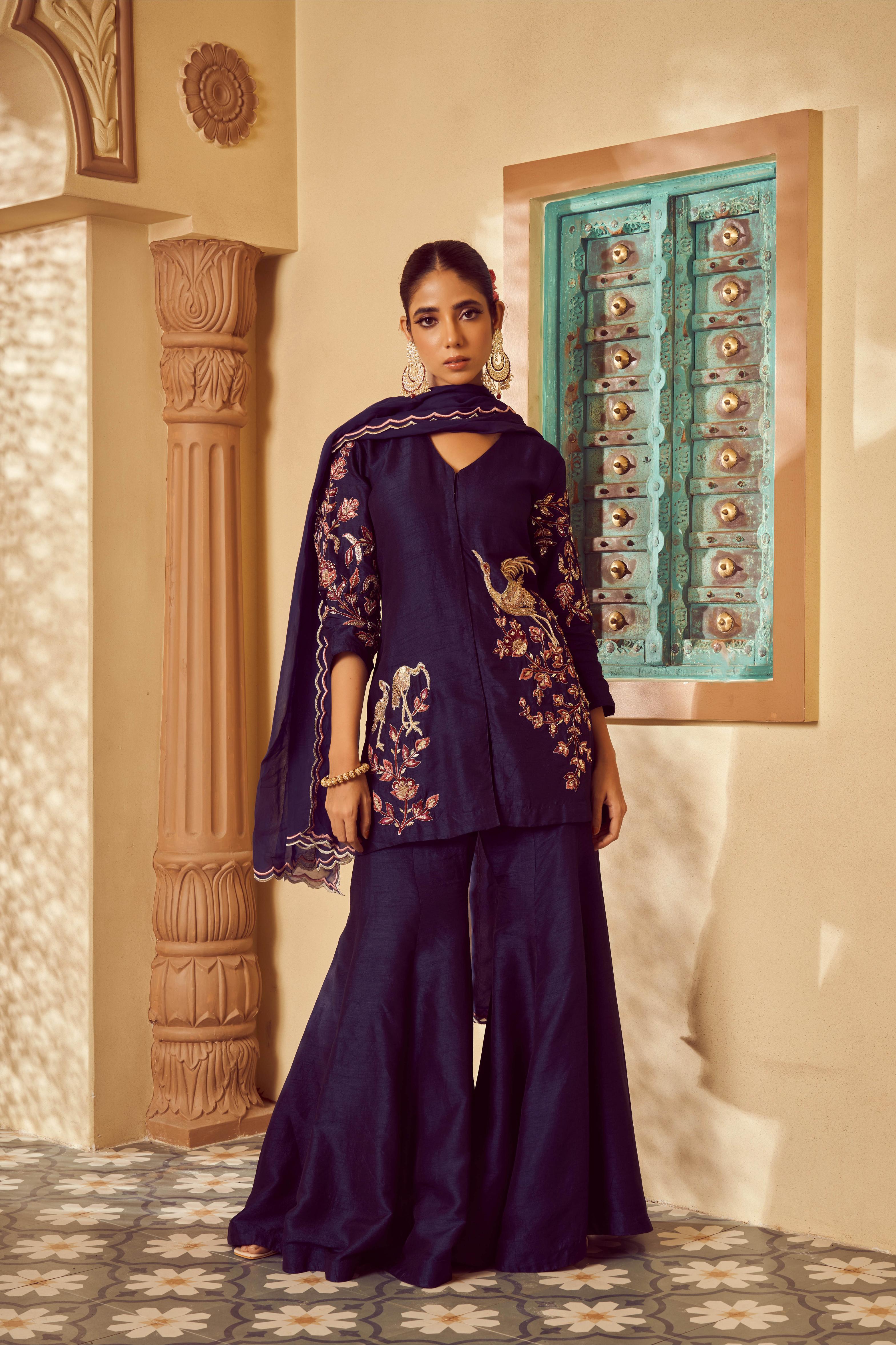 Featuring dark Blue silk embroidered short kurti paired with plain silk sharara and organza dupatta