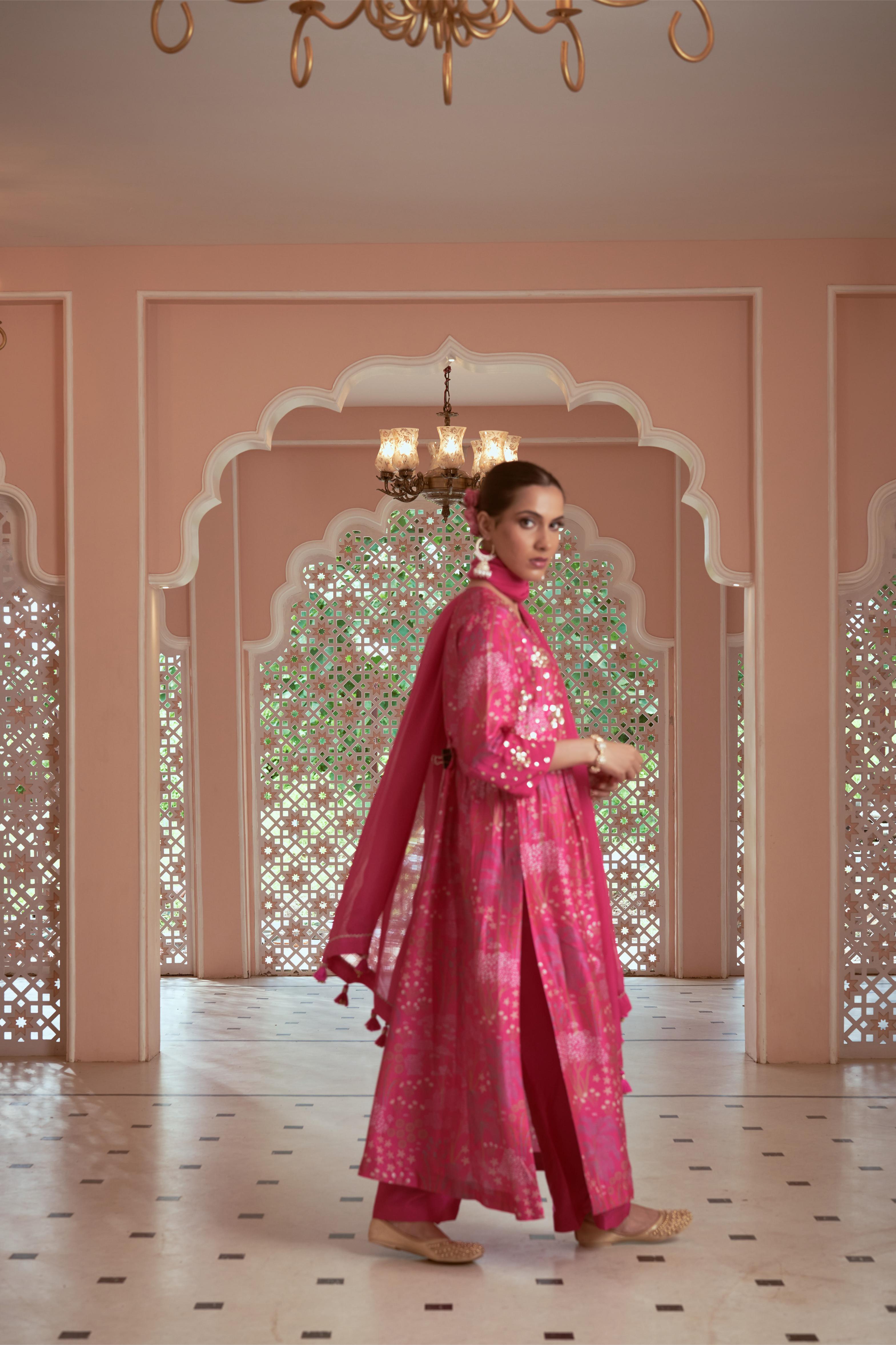 Featuring signature print pink kurti adorned with hand embroidery paired with silk pants and organza dupatta