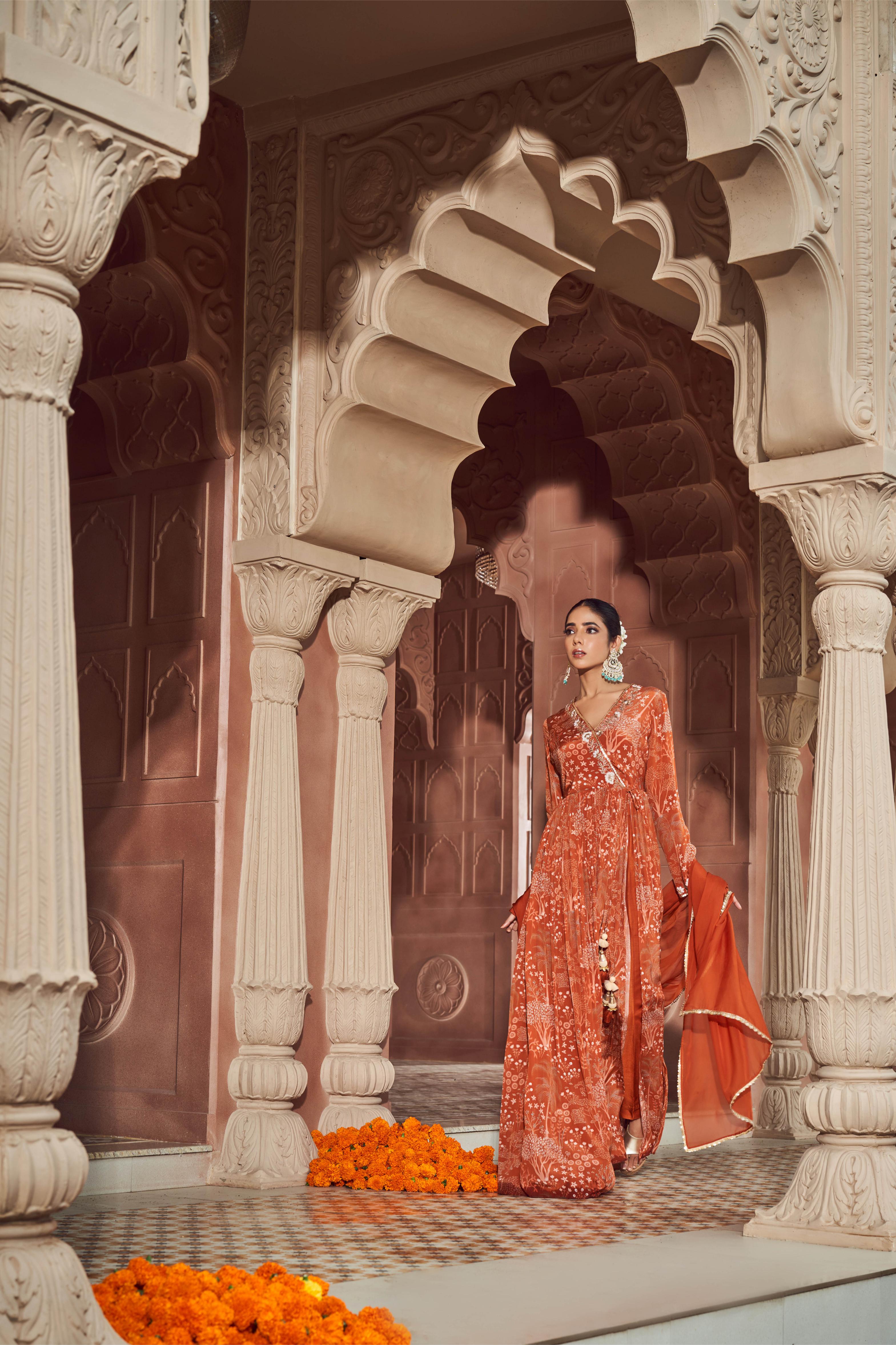 Rust orange signature print front slitted anarkali paired with silk pants and organza dupatta