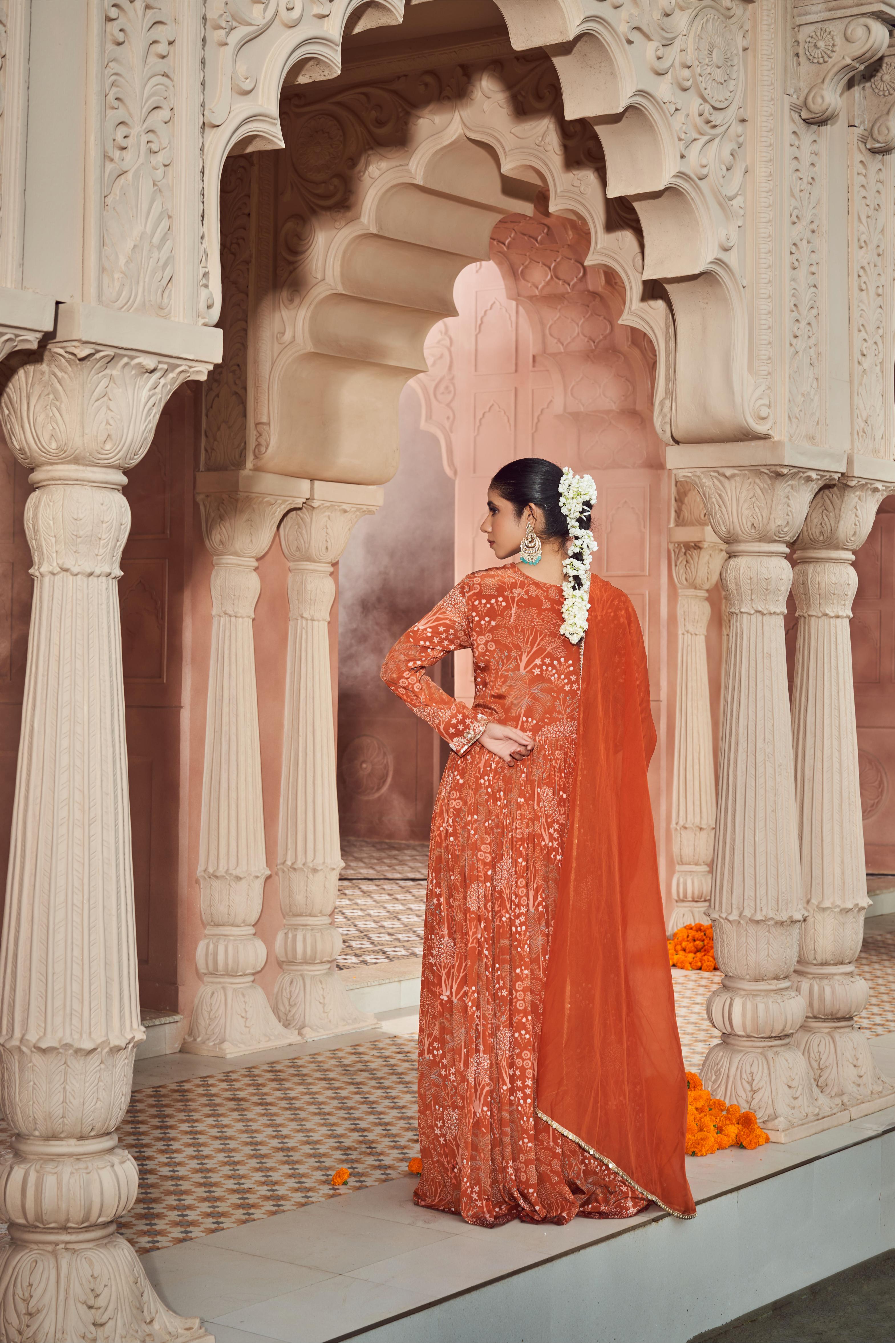 Rust orange signature print front slitted anarkali paired with silk pants and organza dupatta