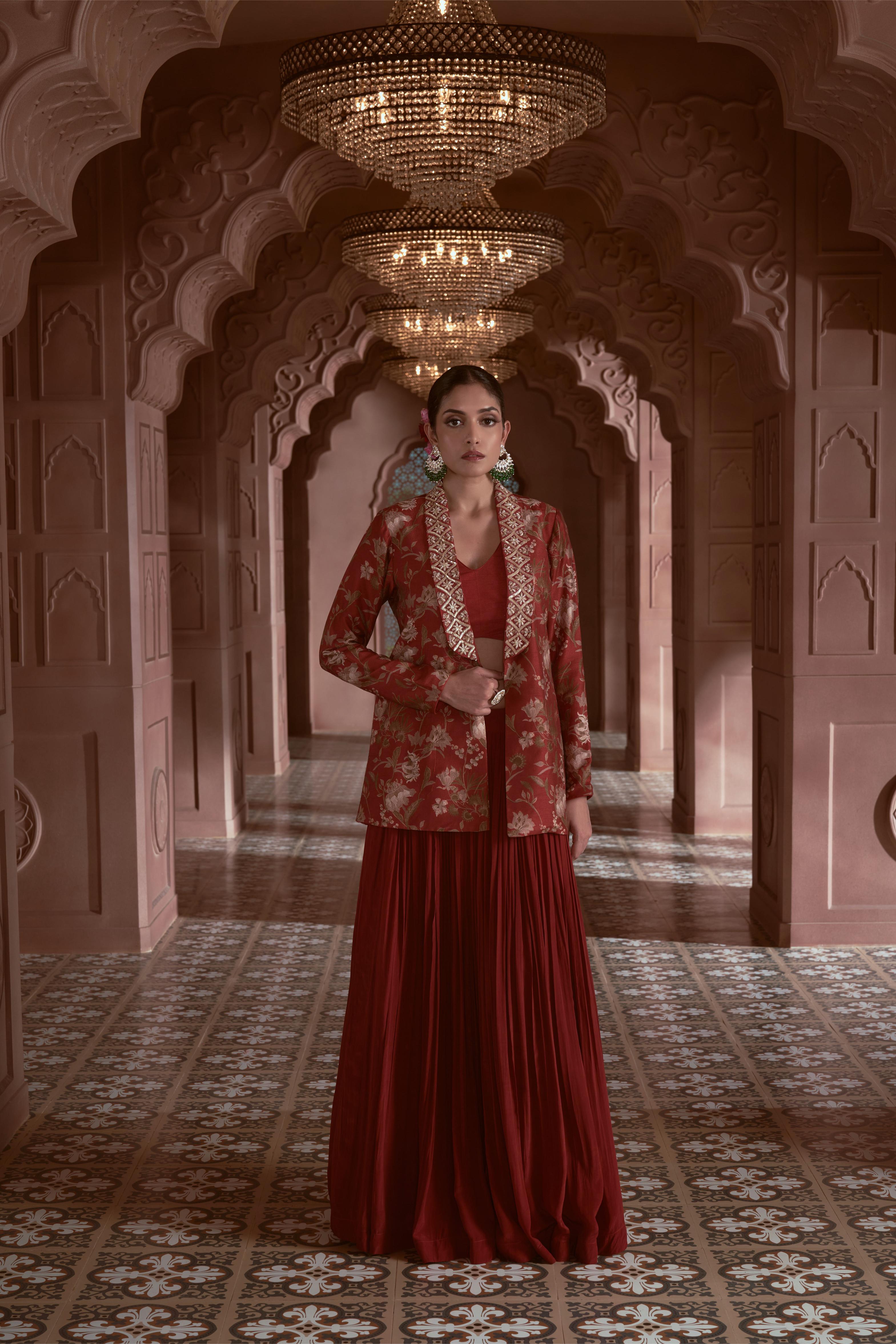 Featuring Maroon floral print silk jacket with hand embroidery on the collar paired with gathered crepe skirt and bustier